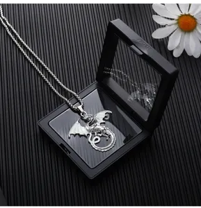 Vista detallada del collar con colgante de dragón luminoso en elegante caja de regalo.