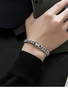 Closeup of titanium steel Cuban link bracelet on wrist, trendy niche jewelry detail shot.