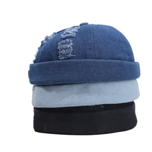 Detailweergave van gestapelde denim docker caps in donkerblauw, lichtblauw en zwart.