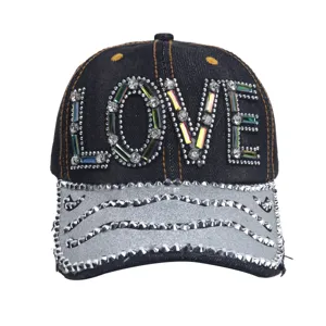 Close-up van een zwarte denim honkbalpet met sprankelende strass stenen en LOVE motief.