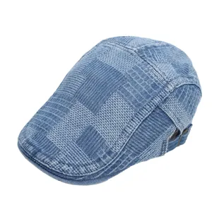 Close-up detail of retro blue denim flat cap, stylish woven pattern and metal buckle.