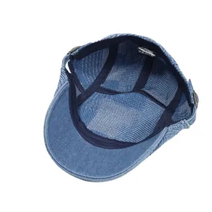 Detail view of blue denim newsboy cap interior, 100% cotton lining, quality stitching.