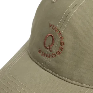 Gedetailleerd overzicht van olijfgroene honkbalpet met geborduurde letter Q en vintage ontwerp.