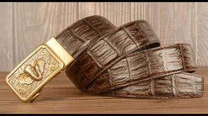 Men leather belt detailed view featuring embossed crocodile pattern and golden elephant buckle.