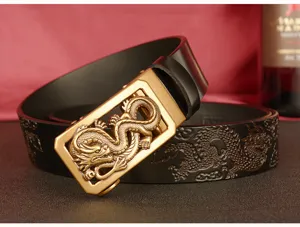Men's black leather belt with gold dragon automatic buckle and embossed strap design.