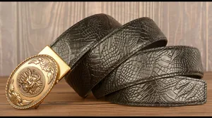 Detailed shot of men leather belt with embossed texture and vintage dragon head metal buckle.