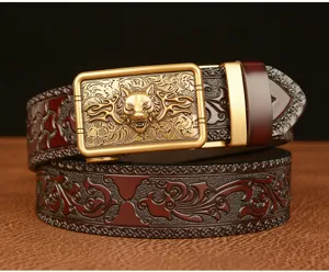 Detailed view of a men's automatic leather belt with wolf head buckle and carved floral pattern.