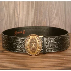 Close-up detail of black crocodile textured leather belt with vintage golden dragon buckle.