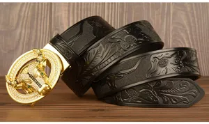 Detail view of men black leather belt featuring ornate gold bull zodiac buckle and carved patterns.