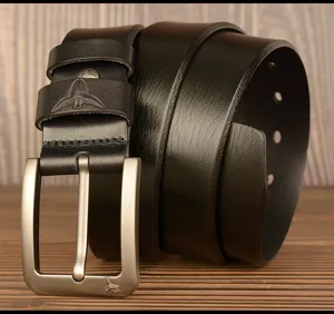 Detailed shot of black genuine leather belt with metal pin buckle on wooden surface.