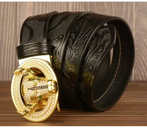 Men's leather belt detail featuring a luxury gold bull head buckle with sparkling rhinestones.