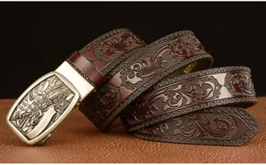 Close-up detail of vintage embossed leather belt with intricate scroll pattern and metal buckle