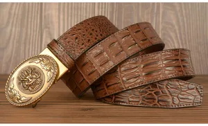 Detail shot of men's brown leather belt with crocodile pattern and golden dragon buckle.
