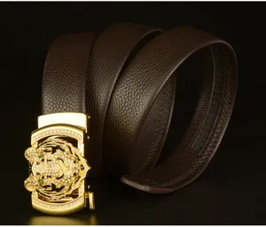 Detail view of men's leather belt featuring a luxury gold rhinestone tiger head automatic buckle.