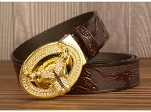Close-up of luxury men leather belt featuring gold rhinestone bull buckle and embossed strap design.