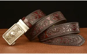Detailed view of men leather belt with wolf head buckle and carved vintage scrollwork patterns.