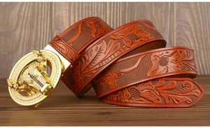 Detailed view of men's leather belt featuring embossed floral design and luxury gold bull buckle.