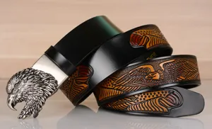 Close-up of mens vintage leather belt with ornate eagle head buckle and embossed pattern.