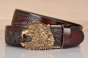 Detailed product shot of retro embossed leather belt with brass eagle buckle and stars.
