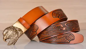 Vintage men leather belt with eagle head buckle and embossed strap design, stylish casual pants.