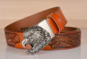 Detailed view of men's leather belt with vintage eagle buckle and embossed pattern.