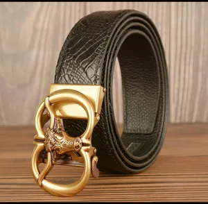 Detail shot of men's leather belt with retro gold bull head automatic buckle and textured strap.