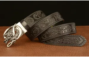 Men's leather belt featuring a metallic crocodile buckle and intricate embossed vintage strap details.