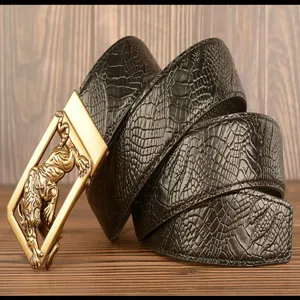 Close-up of men's black crocodile pattern leather belt with gold tiger buckle detail.
