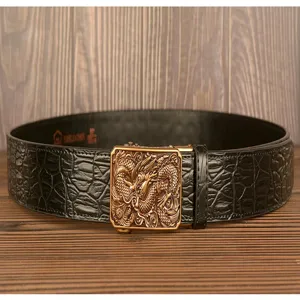 Detailed view of mens leather belt with crocodile pattern and golden dragon automatic buckle.