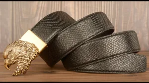 Close-up detail of the retro men's black leather belt featuring an antique brass eagle buckle.