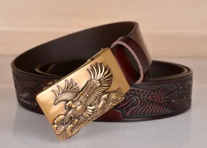 Detail view of men's embossed leather belt featuring metallic eagle automatic buckle.