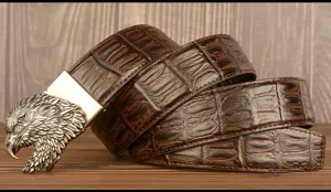 Detailed view of the retro brown leather belt featuring a metallic eagle head automatic buckle.