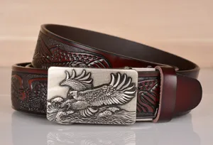 Detailed close-up of mens brown leather belt with eagle embossing and metal buckle.