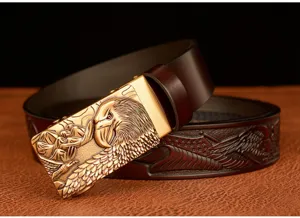 Detail view of a men's leather belt with a golden eagle head automatic buckle and embossed pattern.