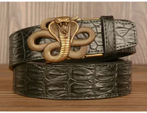 Details of men's leather belt featuring a bronze cobra snake buckle and crocodile pattern.
