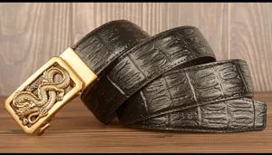 Detail shot of black crocodile pattern leather belt with golden dragon automatic buckle for men.