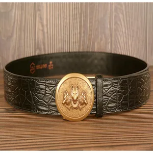 Detailed view of men's leather belt with crocodile pattern and golden wolf head buckle.