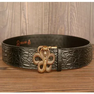 Detail shot of men's leather belt featuring crocodile pattern and unique brass cobra buckle.