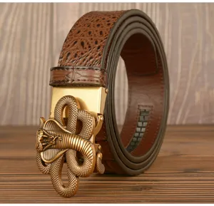 Close-up detail of mens alligator pattern leather belt with cobra metal buckle on wood.