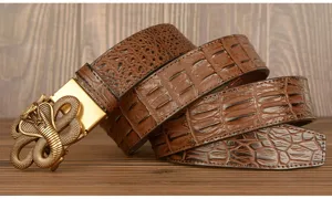 Detailed view of brown crocodile texture leather belt with vintage brass cobra buckle.