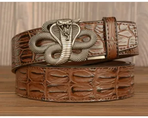 Detailed view of men's brown crocodile pattern leather belt with vintage metal cobra buckle.