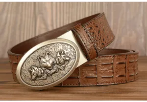 Detailed view of brown leather belt with metallic triple wolf head buckle and croc design.