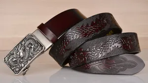 Detailed view of men's embossed leather belt featuring intricate dragon patterns and buckle.