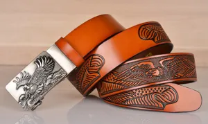 Detail shot of embossed eagle cowhide leather belt with metallic automatic buckle for men.