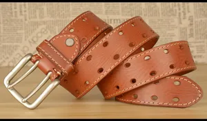 Vista dettagliata della cintura in pelle da uomo con fibbia a doppio ardiglione e cuciture decorative.