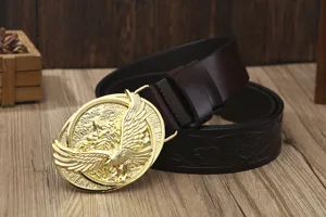 Detail shot of men's leather belt with golden eagle buckle and carved belt strap texture.
