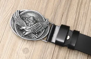 Close-up detail of the vintage leather belt featuring a detailed metal eagle buckle design.