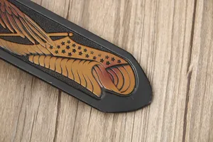 Detail view of the men's leather belt featuring intricate Western eagle and star tooling.