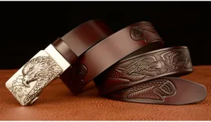 Detailed view of men's leather belt featuring a metallic eagle head buckle and embossed strap.