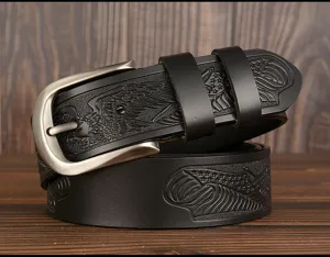 Detailed view of black leather belt featuring carved eagle and flag motifs with metal buckle.